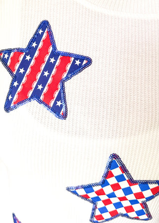 close up of white ribbed short sleeve top with patriotic star patches, sequin detail.