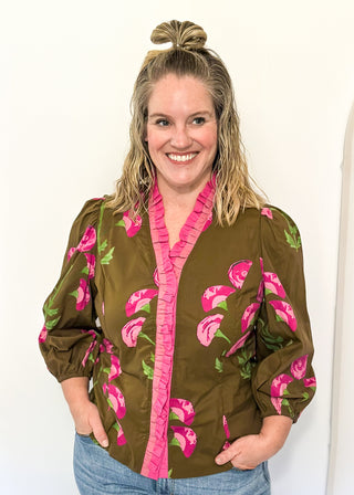 pink florals on brown long sleeve top with shades of pink ruffle around collar and down the front - button up