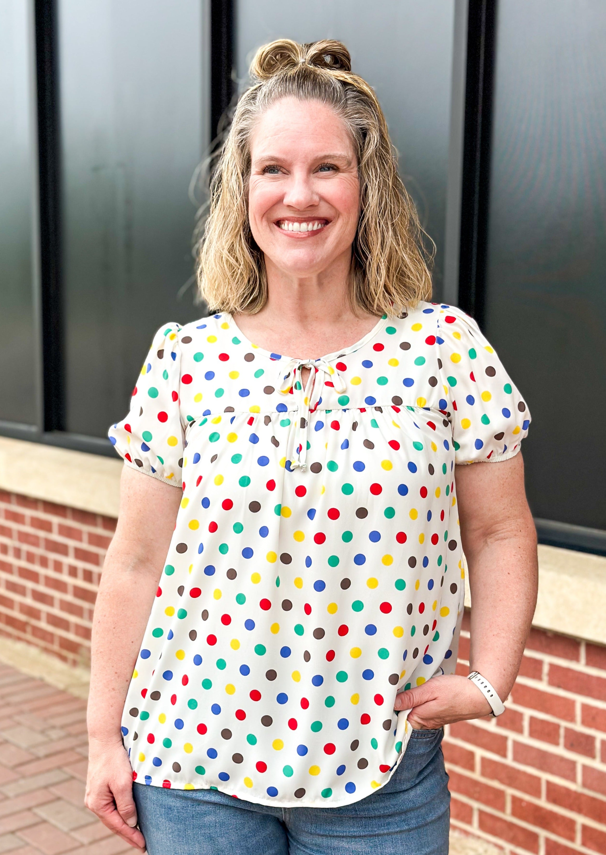 Polka dot print on off white short sleeve top - dots are black, yellow, red, blue and green - tie neck