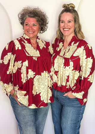 Models in longsleeve burgundy floral top.