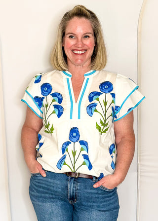 white top with oversized blue flower pattern and short sleeves