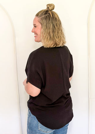 Solid black textured blouse with a V-notch neckline, short sleeves
