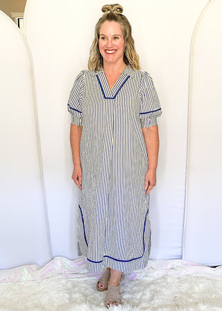 Blue and cream striped midi dress with short sleeves, split V-neckline with contrast trim, pockets, and a relaxed fit.