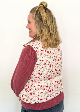 Reversible puffer vest with red and pink floral on one side, brown corduroy on the other.  Pockets on both sides, collared with zipper closure.