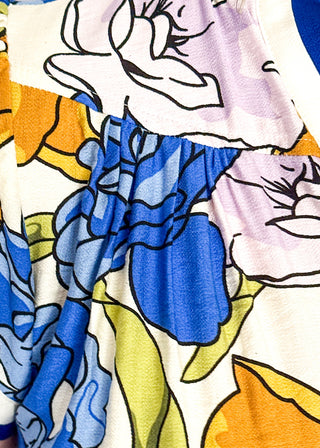 Floral top featuring blue, yellow, and lavender blooms with blue contrast trim on neckline and sleeves.
