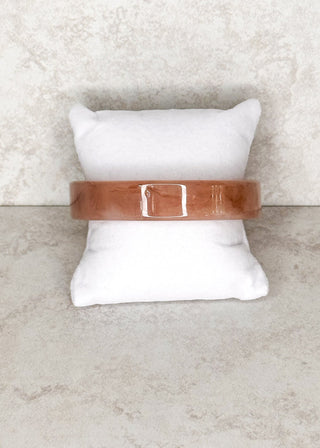 Blush bangle bracelet displayed on a stand