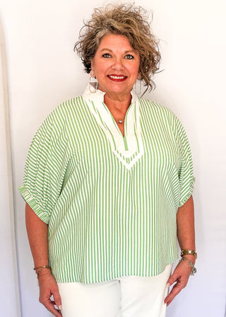 Striped seersucker top in green and white with short sleeves, relaxed fit, and split neckline.