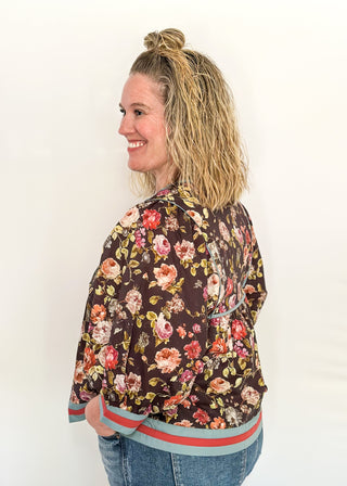 Fall floral Babydoll top with 3/4 puff sleeve, orange and blue strip detail on banding of hem and sleeve. blue ribbon detail on the front and tie at the collar. 