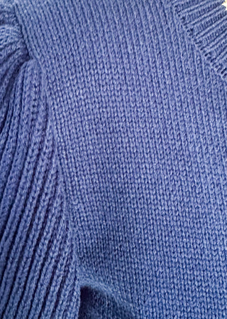 close up of blue ruffle sleeve sweater with white stitched bird