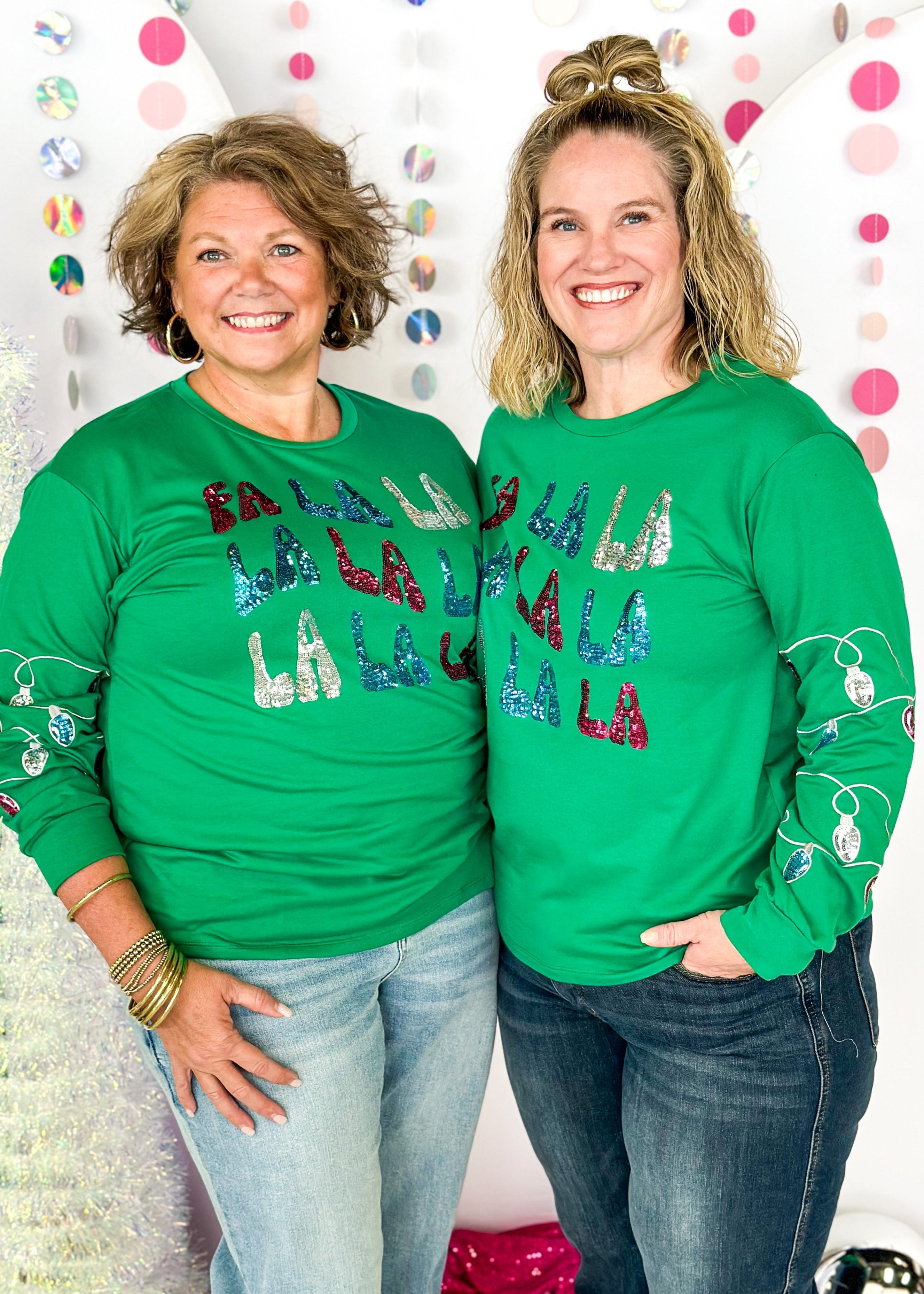 green long sleeve top with fa la la la la la across the front in sequin patches with sequin Christmas lights on the sleeves starting around the elbow down