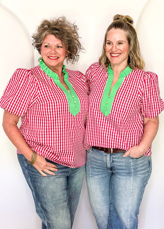Women’s gingham blouse with decorative buttons and statement neckline detail.