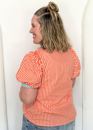 Striped button-down top with V-neckline, short puff sleeves, and contrast trim detailing