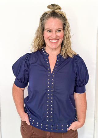 Navy v-neck blouse with puff sleeve.  Silver stud detail along hem, collar and down the front. 