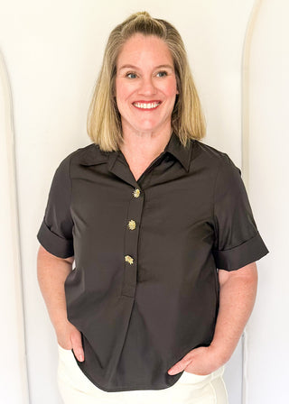 Collared black blouse with detailed gold snaps. short sleeve