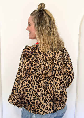 long sleeve leopard print top with red trim v-neck and buttons down the v; ruffle on shoulder 