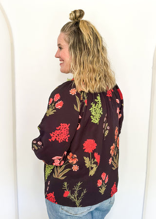 black button up long sleeve top with red flowers and greenery - red and green scalloped stripe detail along collar and down front 
