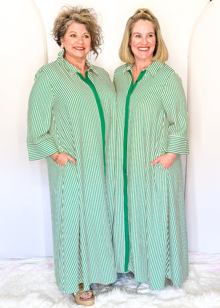 Green vertical striped collared dress with button-down front with green contrast, 3/4 sleeves, midi length, and side pockets.