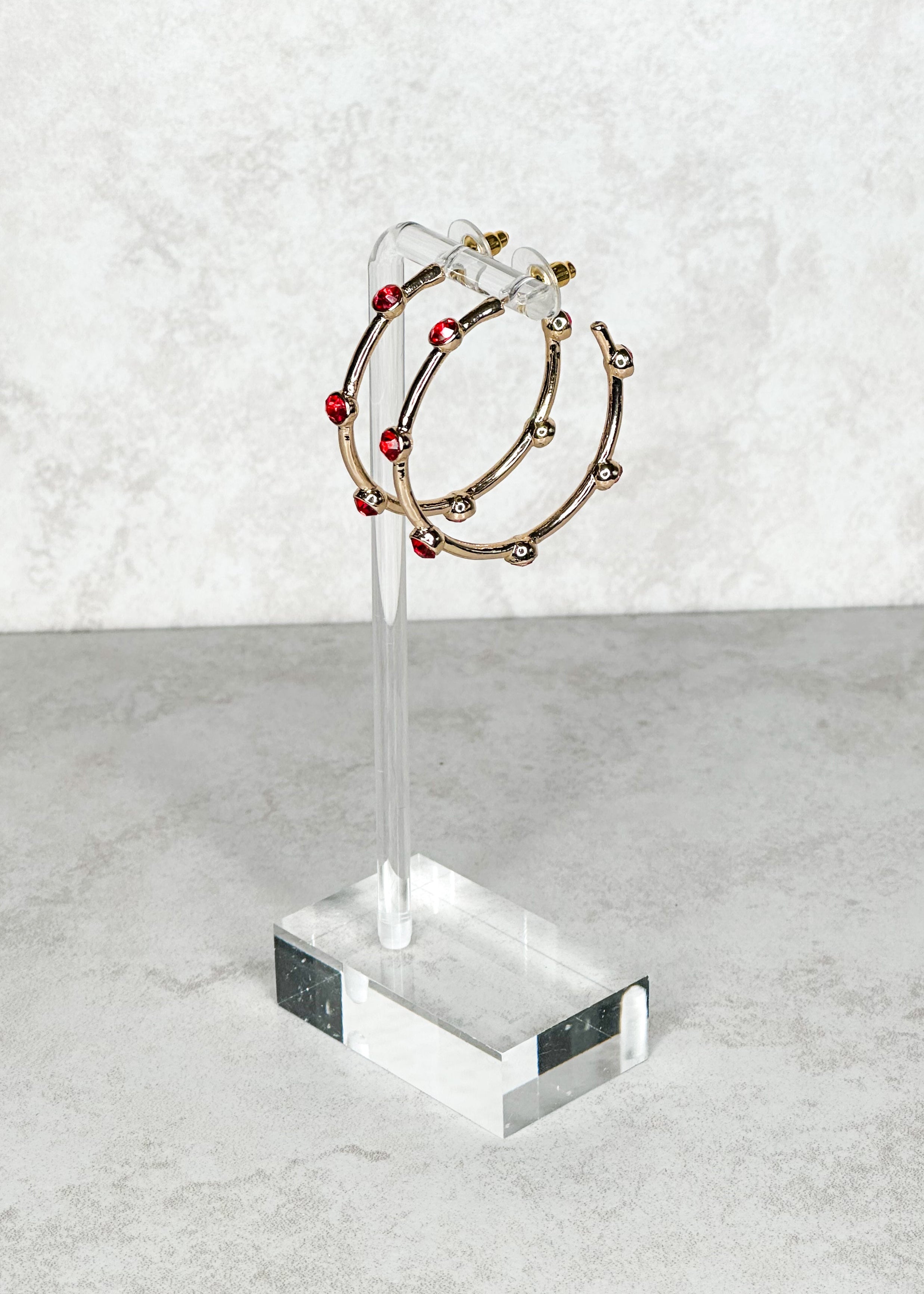 Gold with red colored jewels, open hoop, post back earrings.