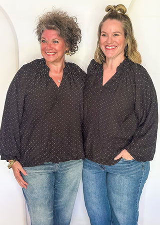 models in black bubble hem long sleeve top with white dots.