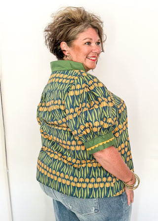 Large puff sleeve top with golden tulips and green leaves.  Contrast is green with yellow scallop detail-short sleeve and v-neck.