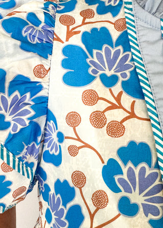 blue floral with large double ruffle short sleeve top - ruffles trimmed in blue and white striped contrast also runs along v neck- ruffle color - brown stems