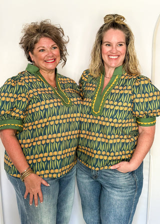 Large puff sleeve top with golden tulips and green leaves.  Contrast is green with yellow scallop detail-short sleeve and v-neck.