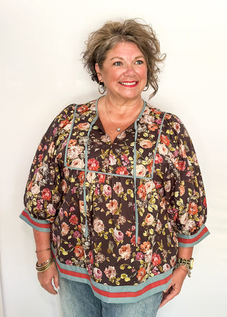 Fall floral Babydoll top with 3/4 puff sleeve, orange and blue strip detail on banding of hem and sleeve. blue ribbon detail on the front and tie at the collar. 