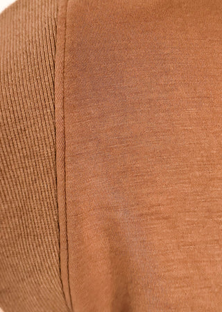 Close-up of a brown ribbed knit fabric, showing the texture and stitching detail of a garment.