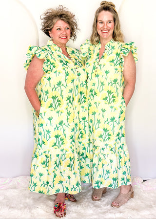 Women’s flowy maxi dress with green and yellow floral pattern and ruffle sleeve detail.
