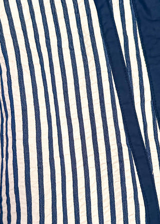 close up of an Indigo colored Entro dolman striped top with contrast trim.