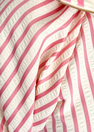 Close up of pink striped short sleeve 1/4 zip top with lightweight fabric, stripe elastic sleeve and collar detail.