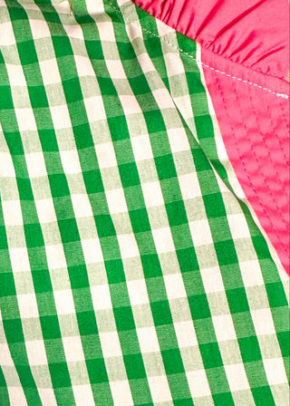close up of women’s gingham blouse with decorative buttons and statement neckline detail.