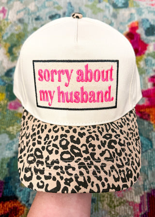 Snap-back canvas hat with spotted bill.  Embroidered patch with "Sorry about my husband" in hot pink and black. 