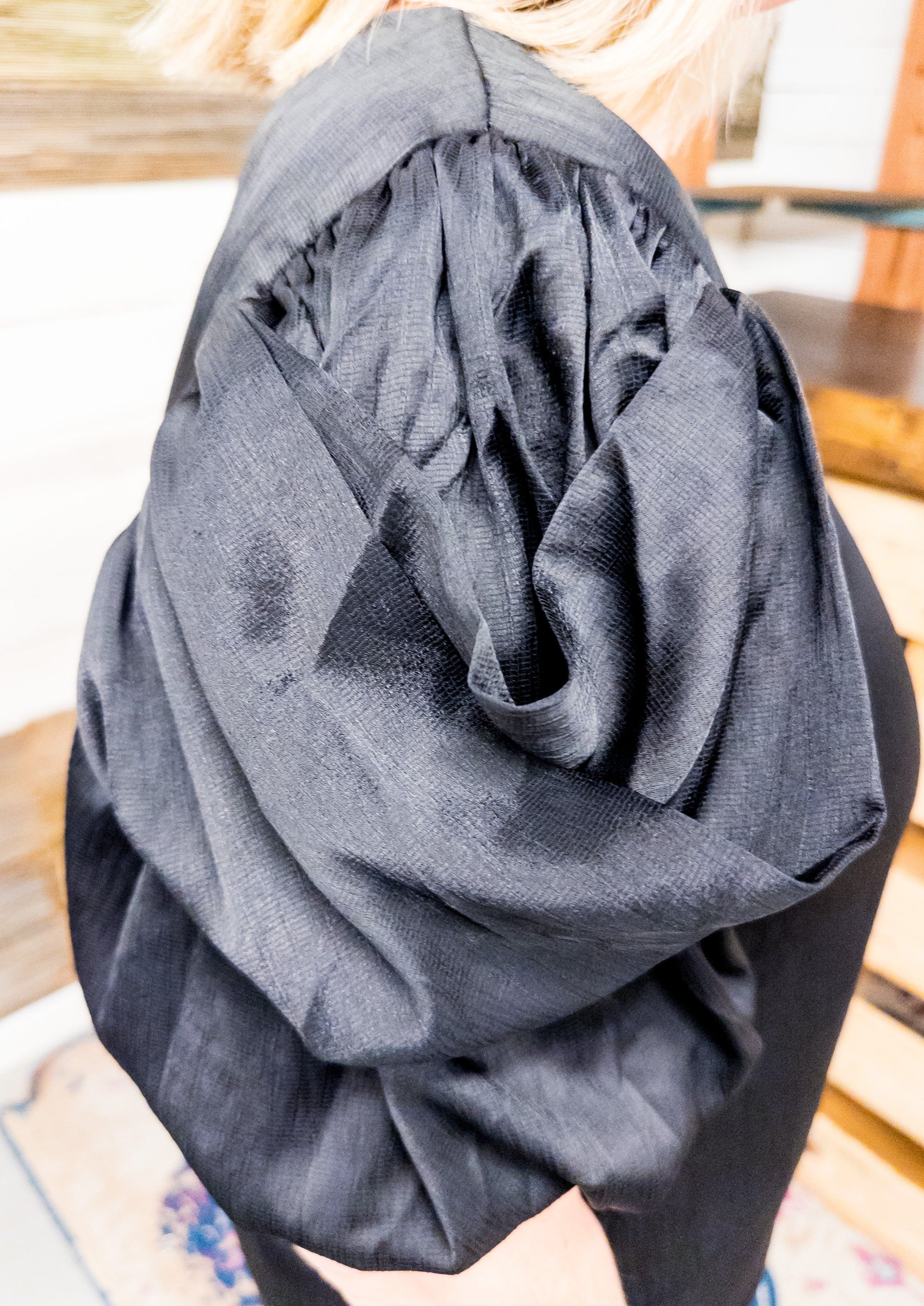 Close up of black draped sleeve showing the detail of the layered sleeve.