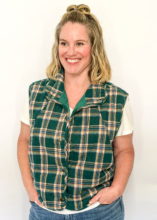 Green plaid puffer vest with snap front and side pockets.