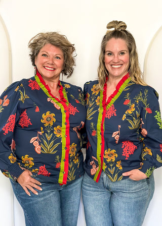 floral long sleeve top with navy background and redish and gold blooms - red and green ruffle around collar and down front - button up