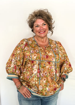 Fall floral Babydoll top with 3/4 puff sleeve, cream and blue strip detail on banding of hem and sleeve. blue ribbon detail on the front and tie at the collar. 