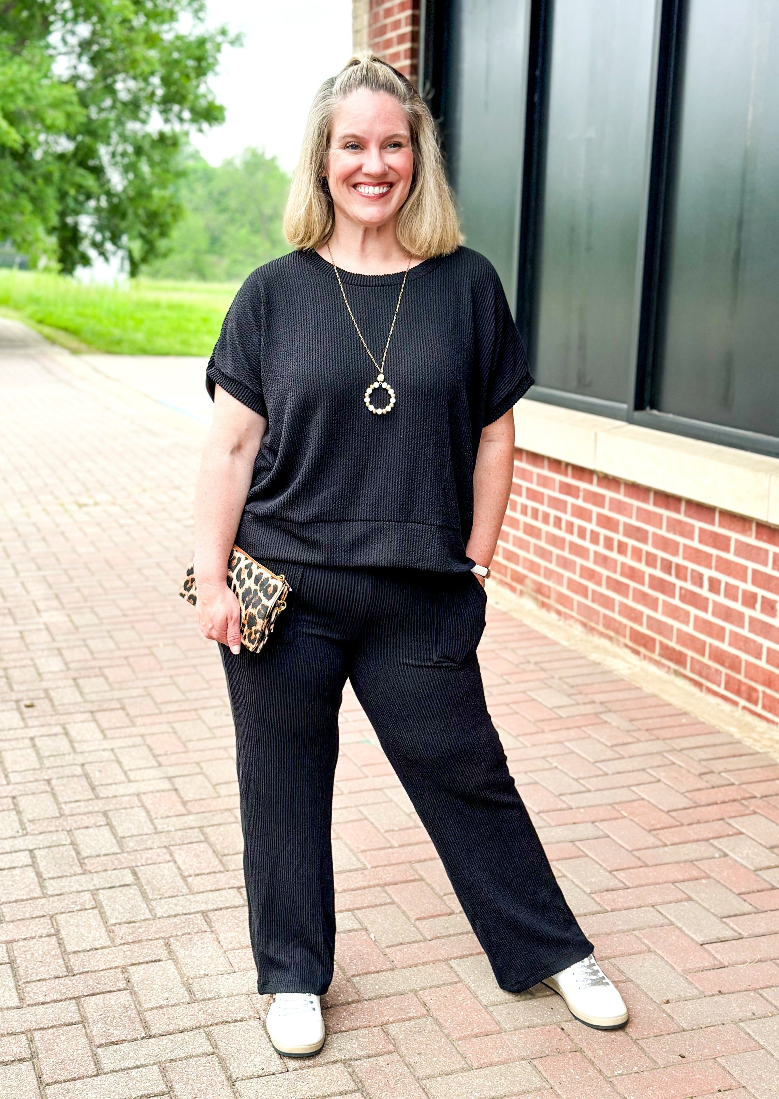 textured black set top and pants - pants have pockets and banded waist - top has a drop shoulder dolman sleeve with banding around the bottom.