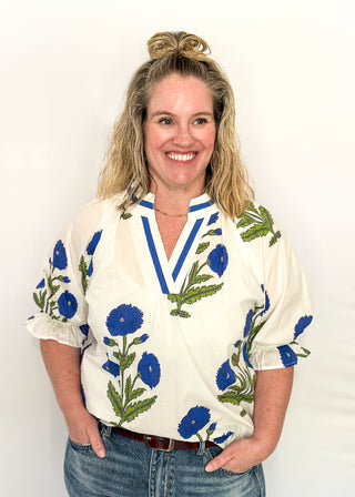 3/4 smocked sleeve white top with large blue blooms. V-neck with blue piping detail. 