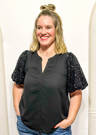 black top featuring sparkly sequin puff sleeves and a relaxed, flowy body.