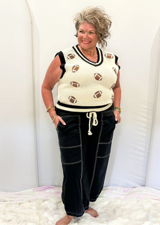 Black balloon style pants with rope drawstring waist. White stitching around pockets and crop cut.