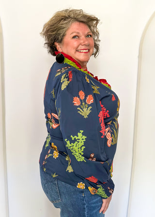 floral long sleeve top with navy background and redish and gold blooms - red and green ruffle around collar and down front - button up