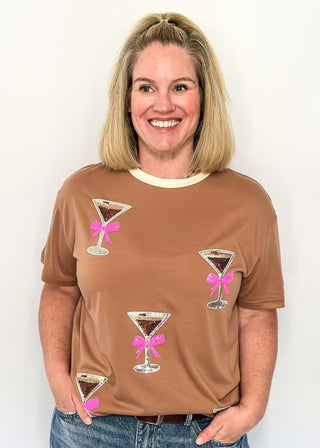 Mocha top featuring sparkling sequin cocktail glasses with pink bows and cream neckline.