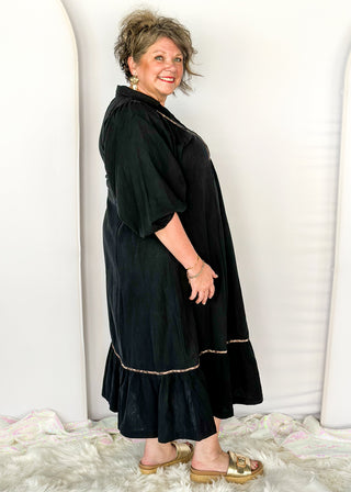 Black V-neck midi dress with leopard print detail on front and around bottom tier. 
