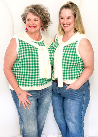 Sleeveless green checkered sweater with faux wrap in cream.