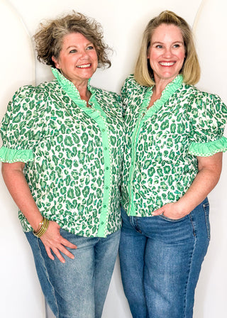 Green animal print blouse with contrast trim, button front, and ruffle sleeves