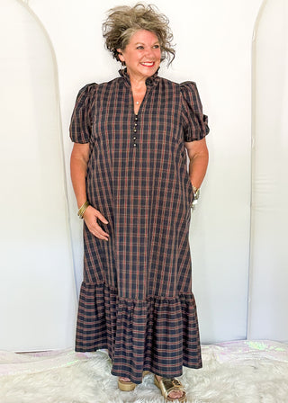 woman wearing a plaid midi dress with puff sleeves and a tiered ruffle hem