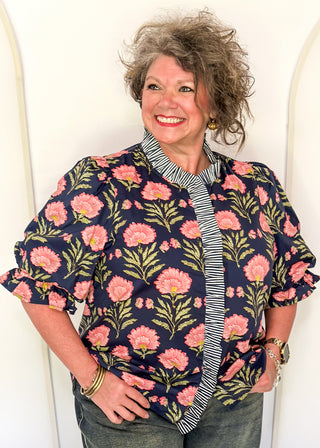 Navy floral puff sleeve blouse with pink oversized floral print and striped contrast trim along the neckline and front placket.