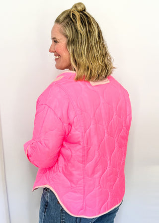 Bright pink quilted jacket with light pink contrast trim, long sleeves, patch pockets, and button-front closure