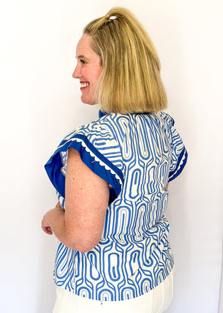 Patterned short-sleeve top in blue with contrast trim with scallops, v-neckline.